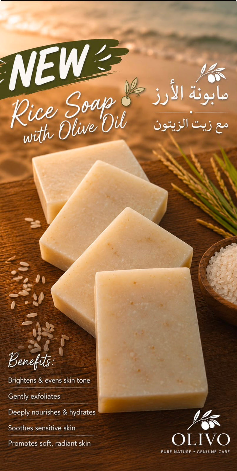 Four rectangular bars of OLIVO Rice Soap with Olive Oil are arranged on a rustic wooden surface, surrounded by rice grains, a small bowl of coarse salt, and olive branches. The background shows a warm, blurred beach scene.